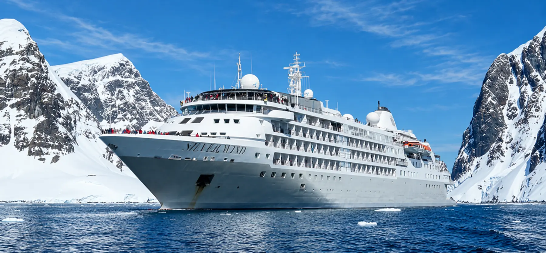 Expedition cruise ship in a mountain-lined polar seascape